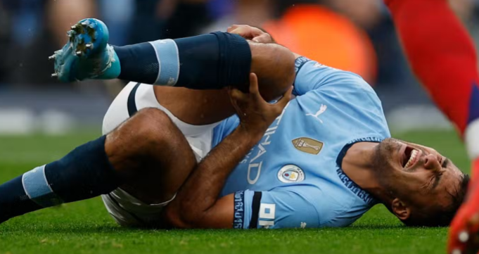 photo of footballer holding his knee in pain following an ACL injury